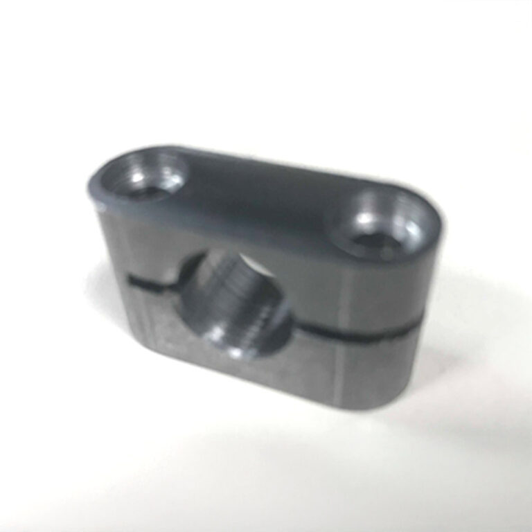 Milled part with two threaded holes and central angled bore
